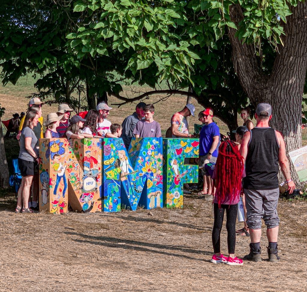 people standing next to a sign that says "NMF"