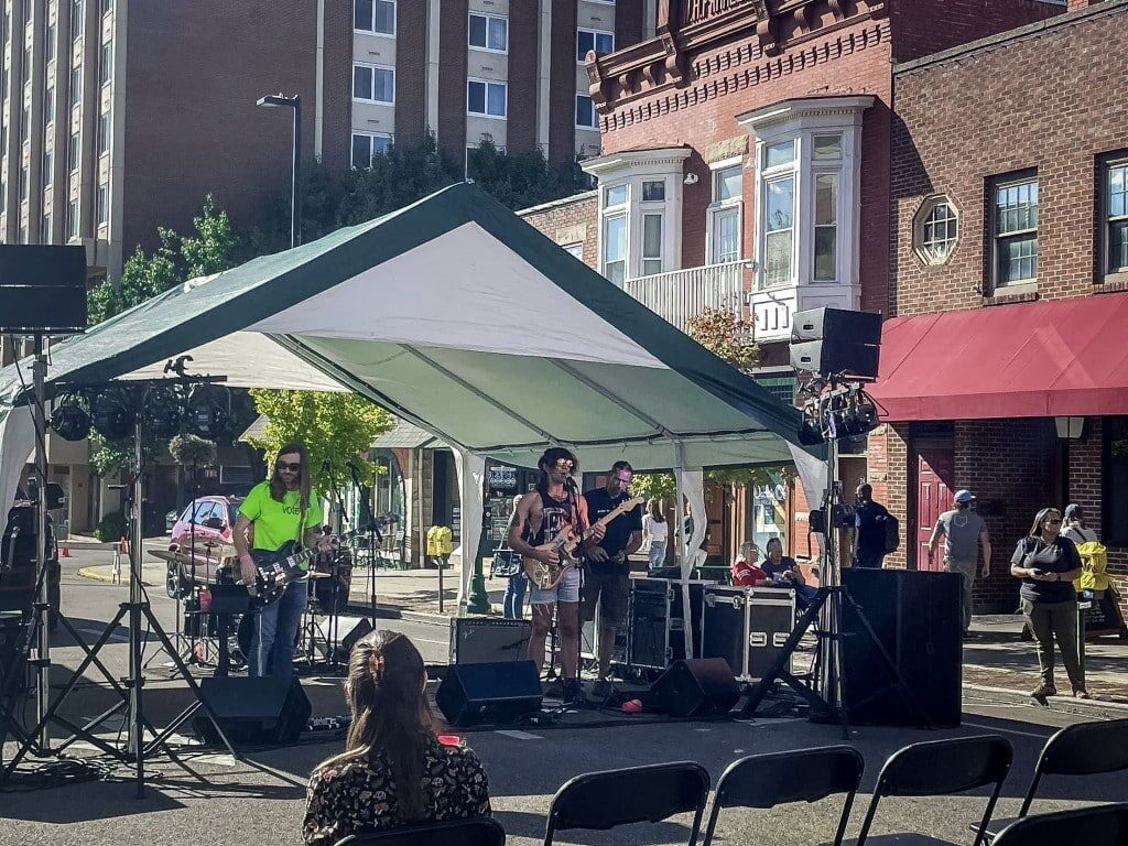 A woman sits and watches a band performing. 