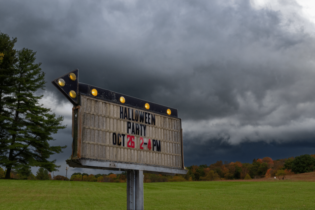 A stormy sky in the background; a sign, overlayed, in the foreground.