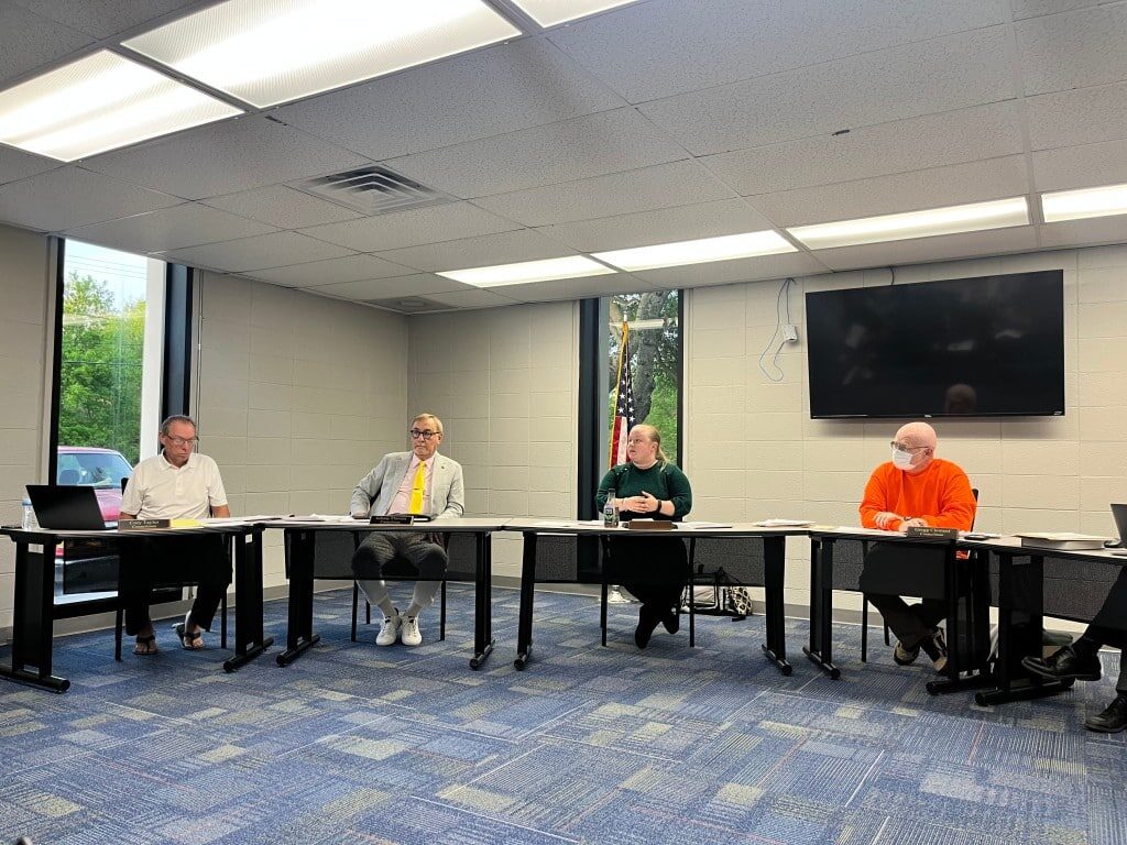 Four Nelsonville City Council members sit at their desks during a public meeting.