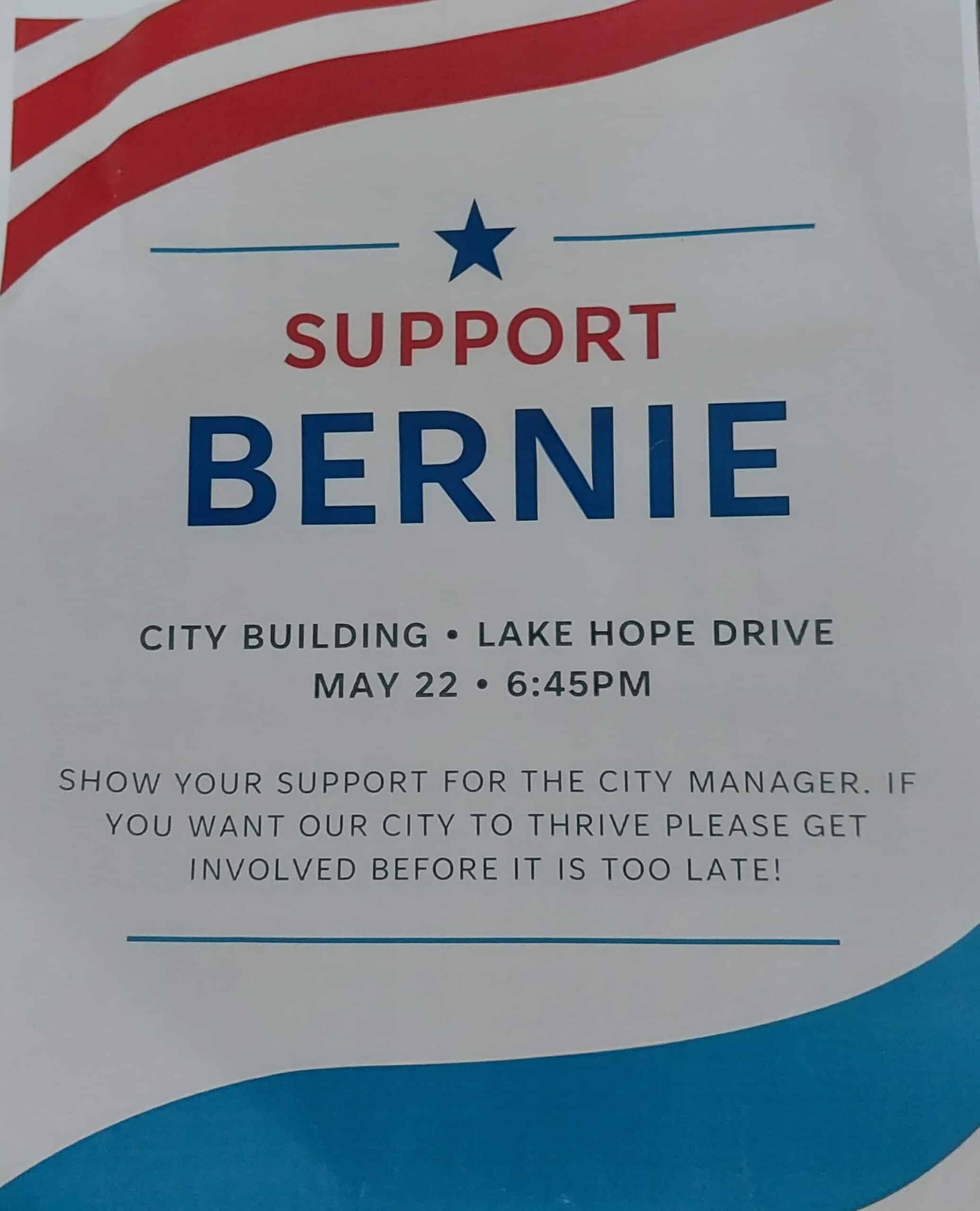 A white flier with red strips, a blue star, blue and red text that reads in capitalized sans serif font:
SUPPORT BERNIE
City Building - Lake Hope Drive - May 22 - 6:45PM
Show your support for the city manager. If you want our city to thrive please get involved before it is too late!