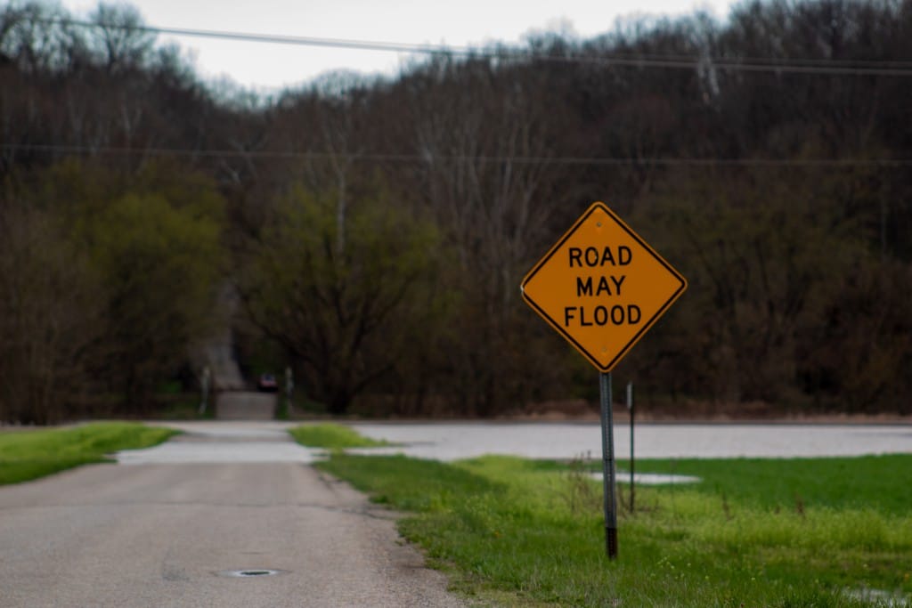 flooded road next to "road may flood sign"
