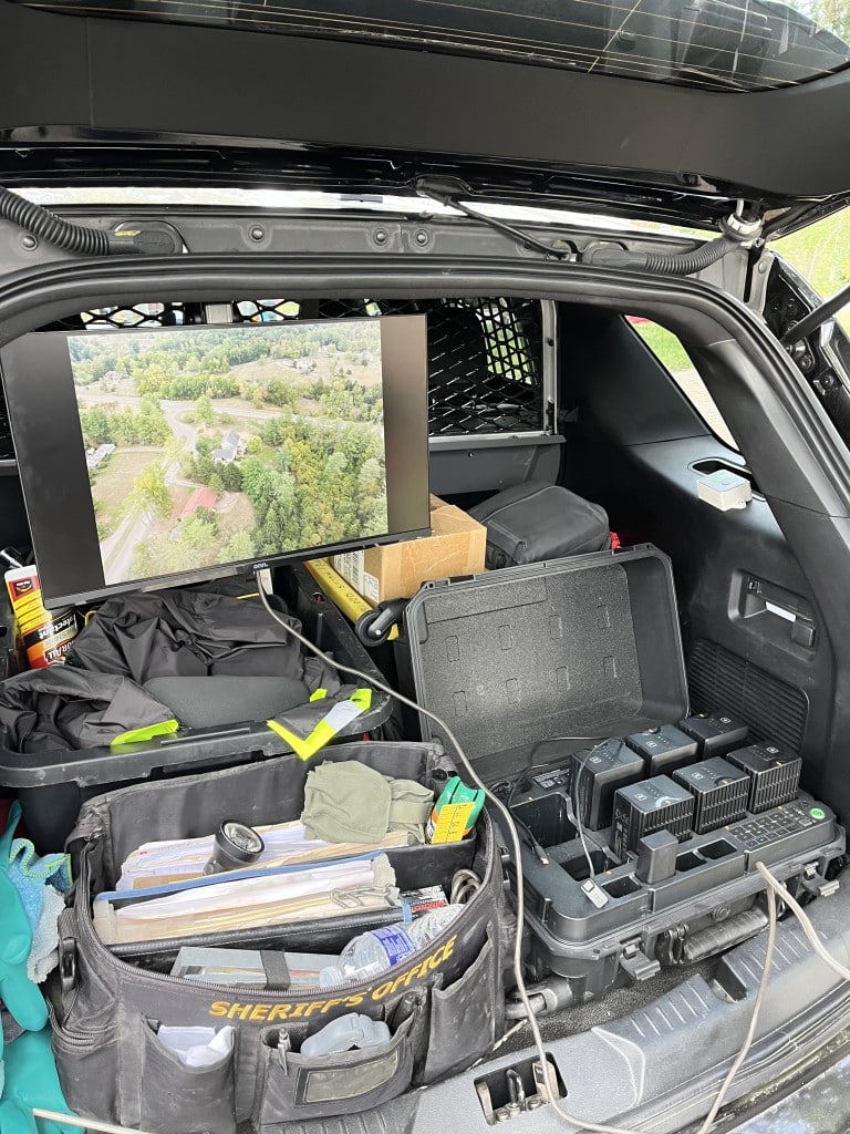 A screen displays drone footage.