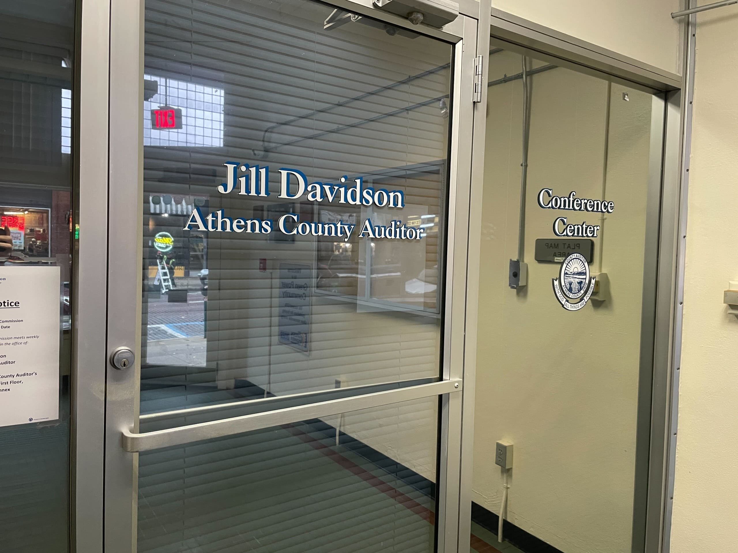 Text over a glass door, "Jill Davidson / Athens County Auditor".
