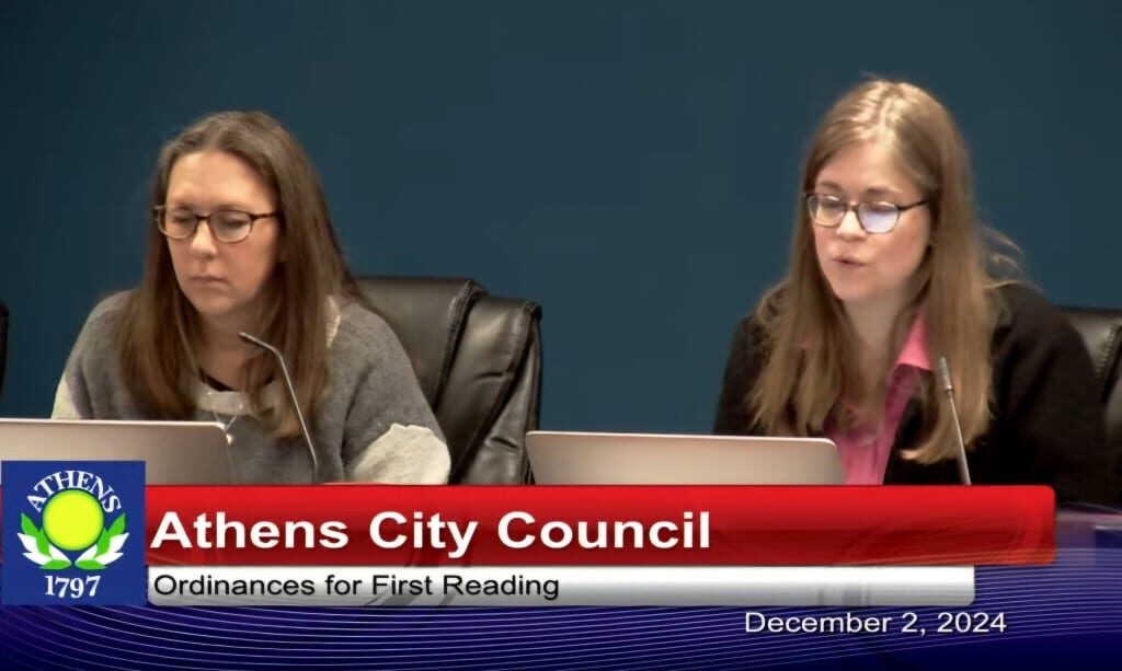 Two women sitting before microphones.