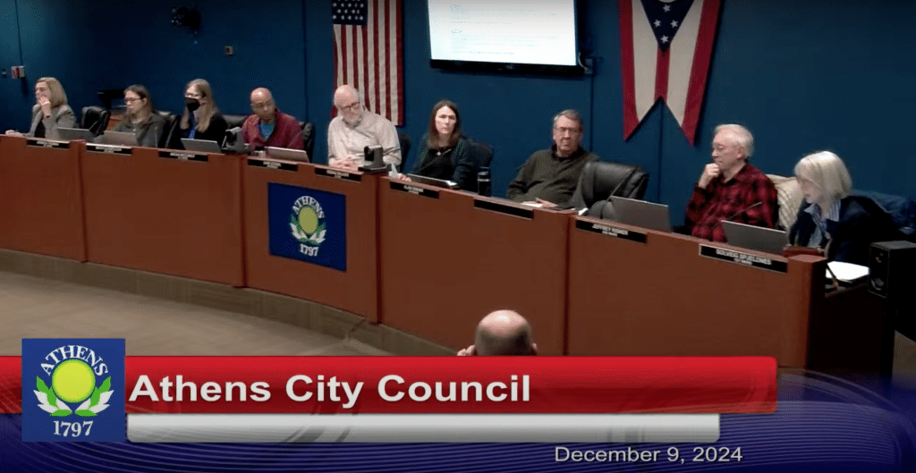 Group of people sitting behind a table.
