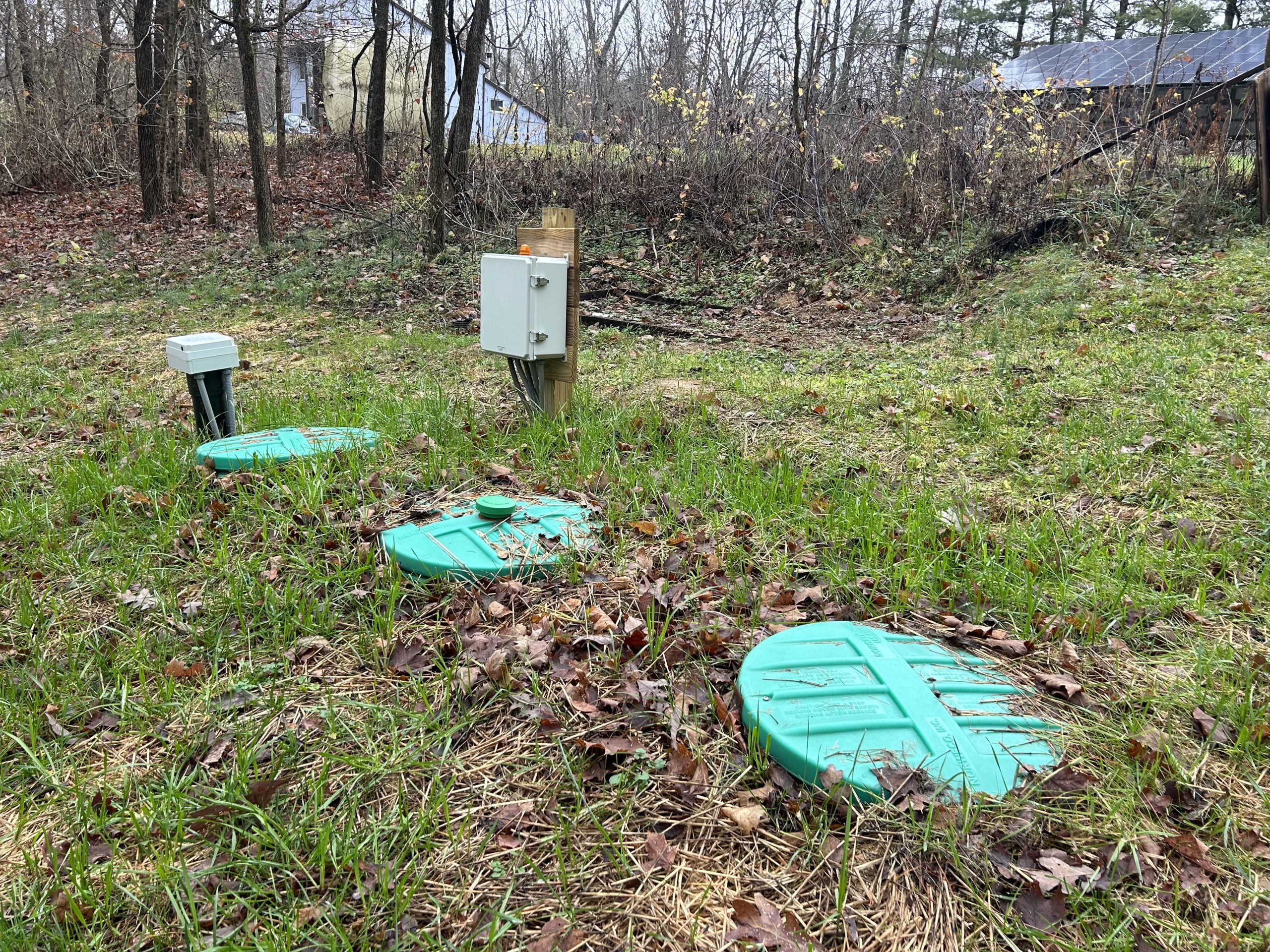 Septic tank lids sit in the ground.