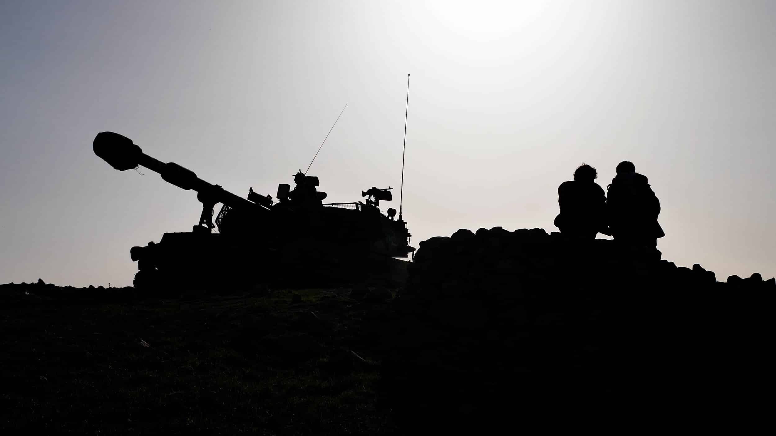 A person stands against a mound of rubble.