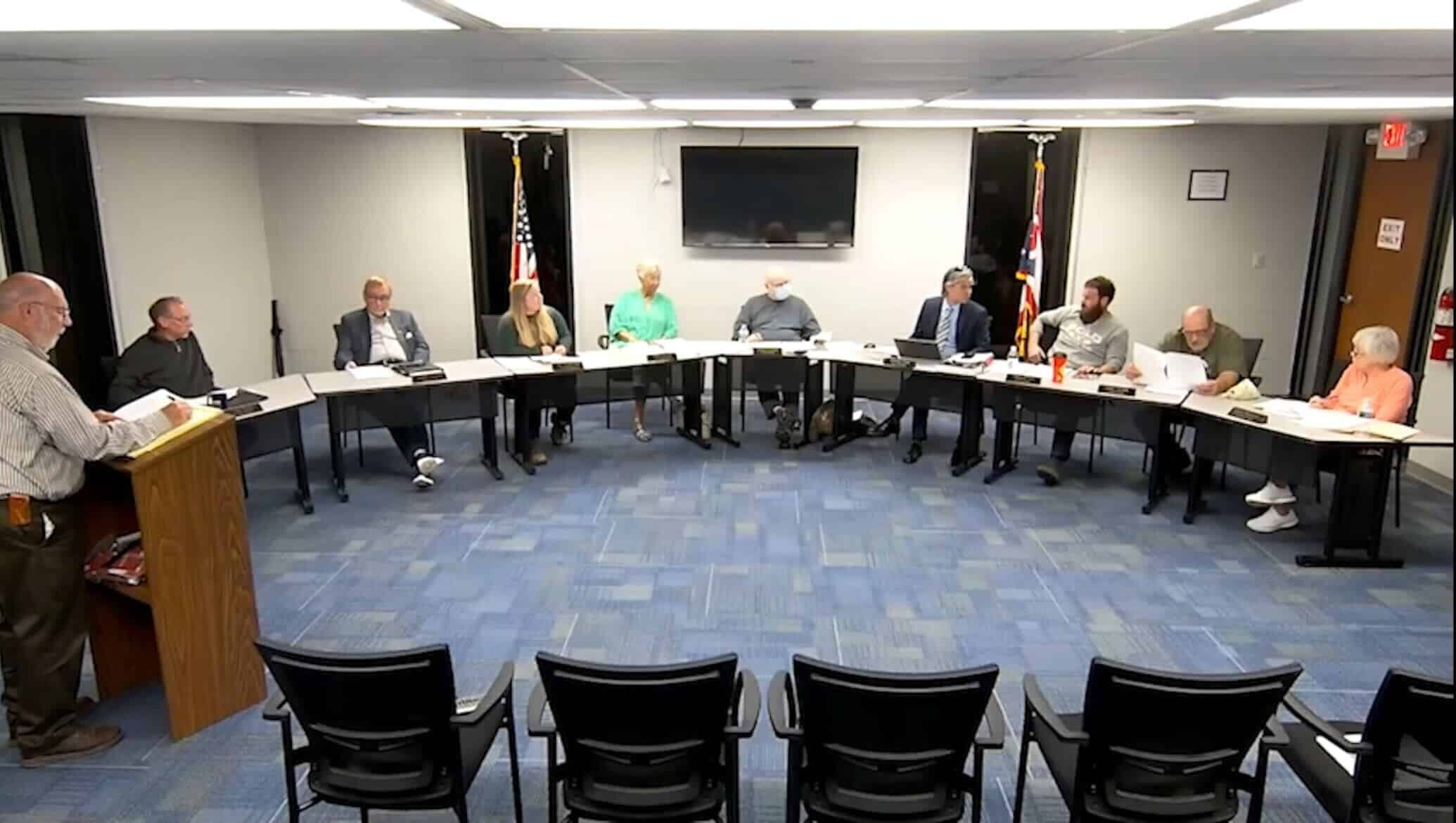 Nelsonville City Council sits around a table.