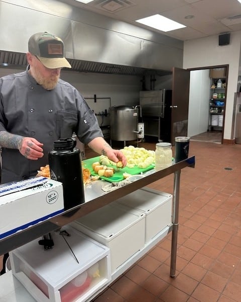 Chef at 740 Kitchen cuts vegetables