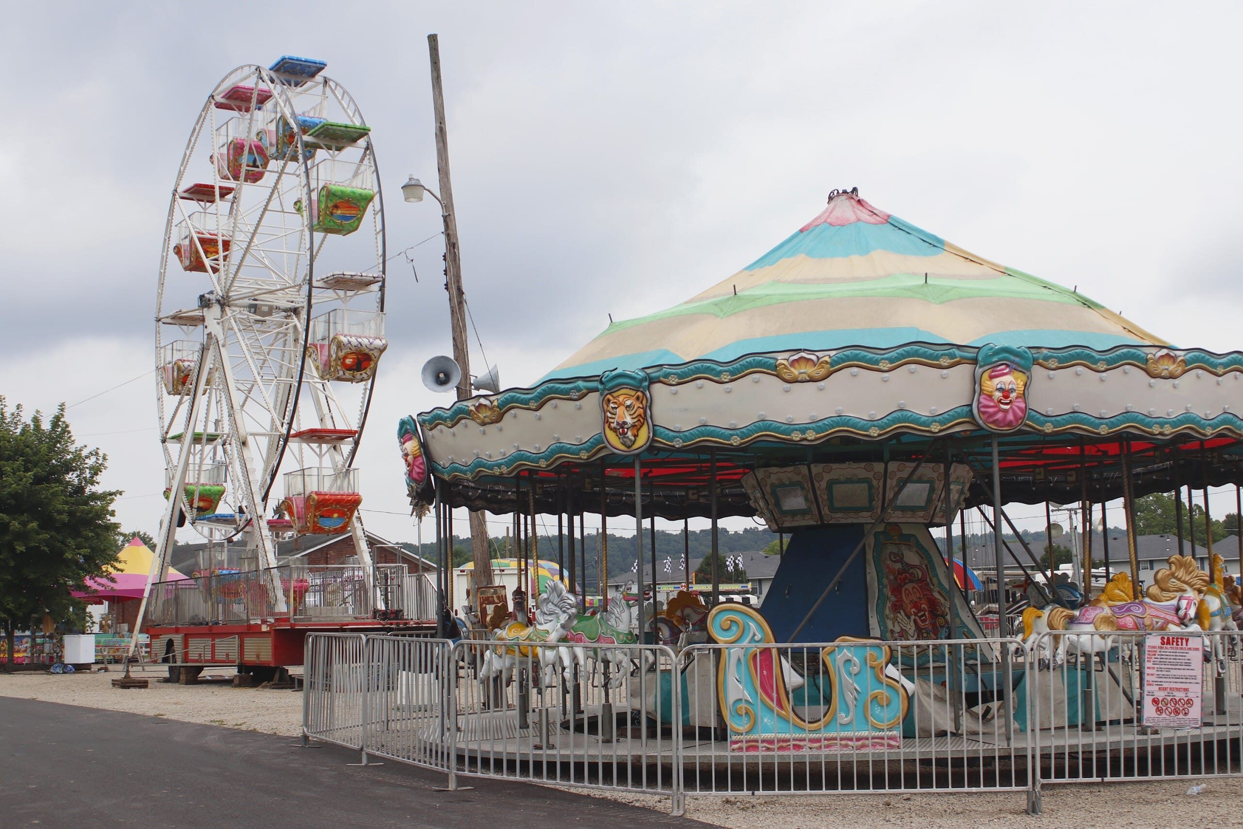 A carousel and a Ferris wheel at the fairgrounds.