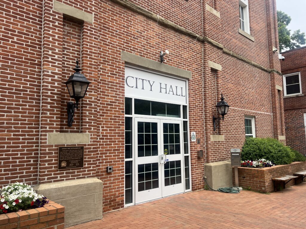 Doors to the Athens City Building with a sign that says "CITY HALL."