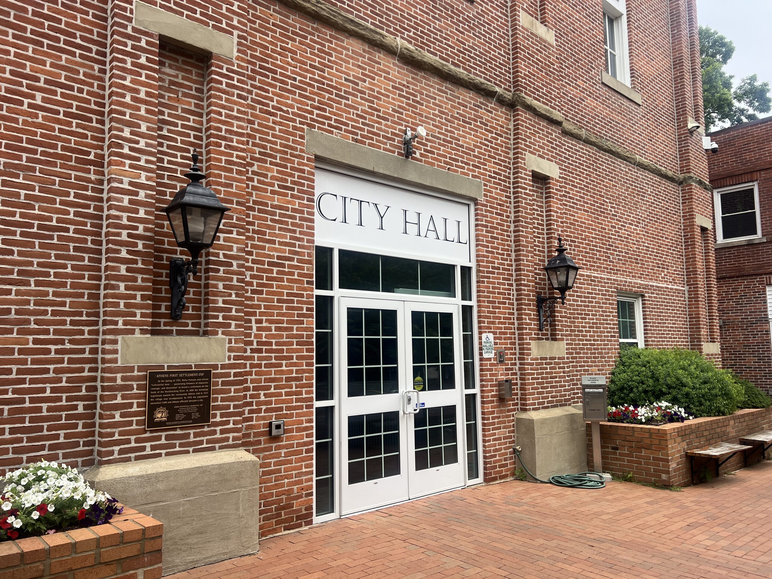 Doors to the Athens City Building with a sign that says "CITY HALL."