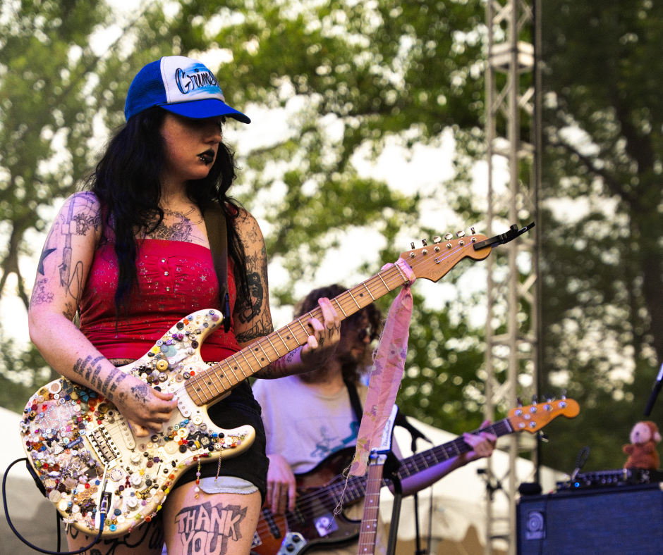 The lead singer of Wednesday playing guitar.