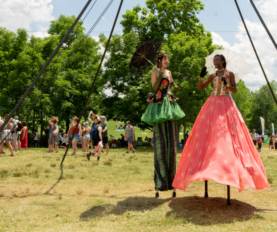 Two women standing on stilts.