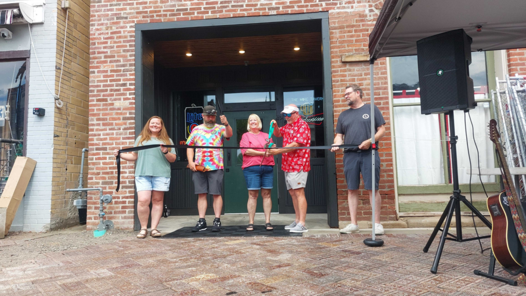 Four people cutting a ribbon.