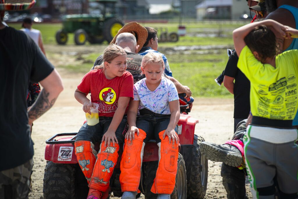 Sierra and Kiley Litten take a break on the back of a four-wheeler in between races at the Athens County Fairgrounds on W. Union Street, Friday, Aug. 21, 2026. Photo by Leah Nairn.