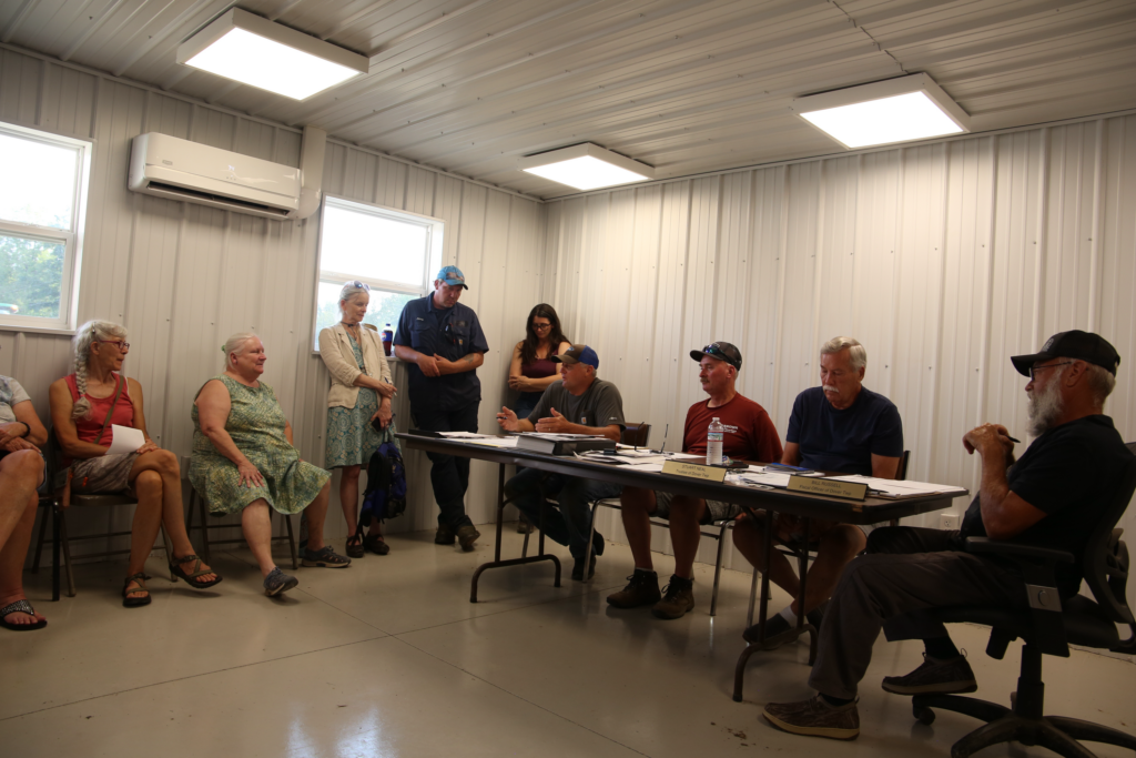 Group of people behind a table, some standing.