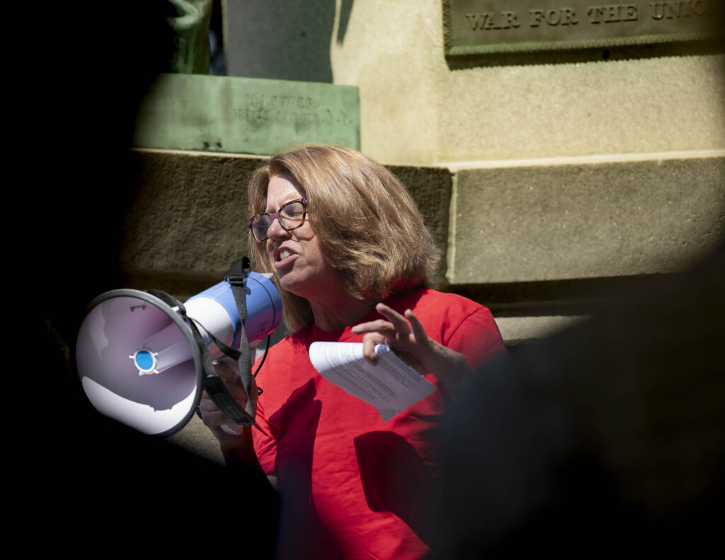Person in red shirt speaking into microphone