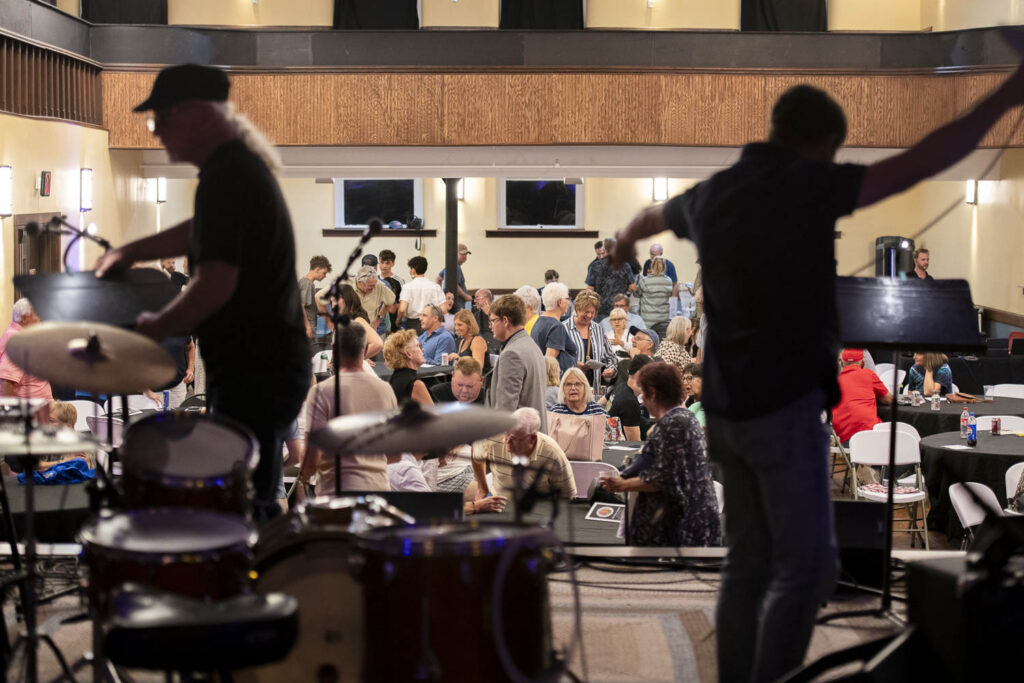 Crowd with shadows of people in foreground with music equipment.