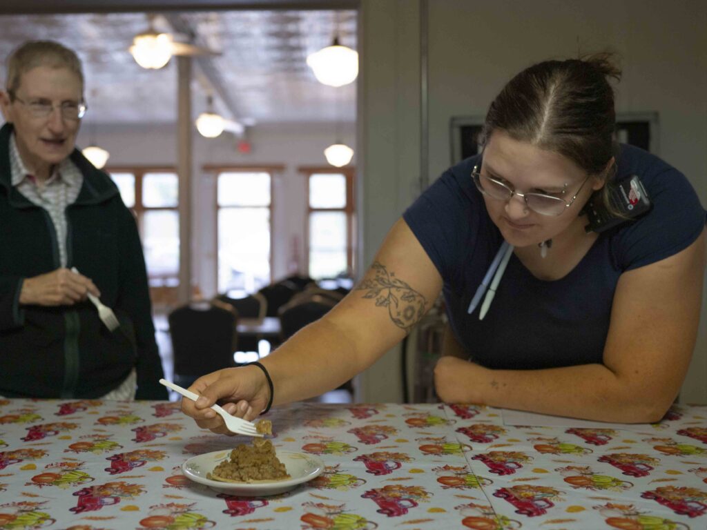 Two people holding forks; one is preparing a bite of pie.