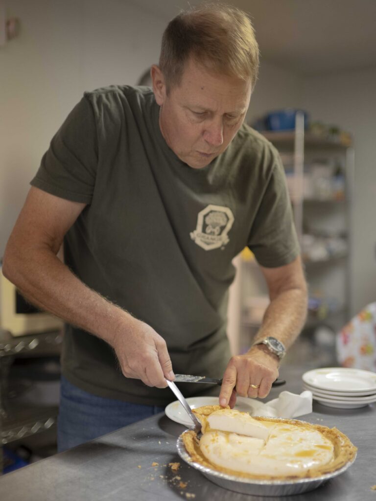 Tim Burns cuts out a slice of a pie.