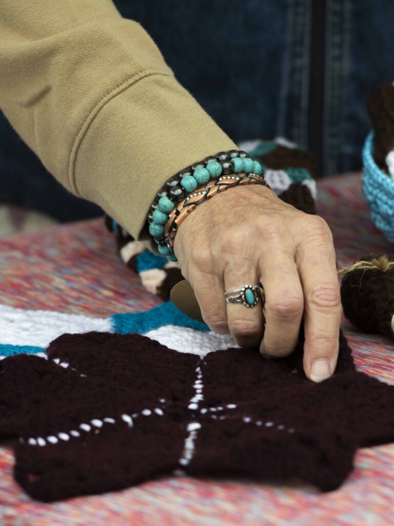 A close-up image of a hand touching a crochet item.