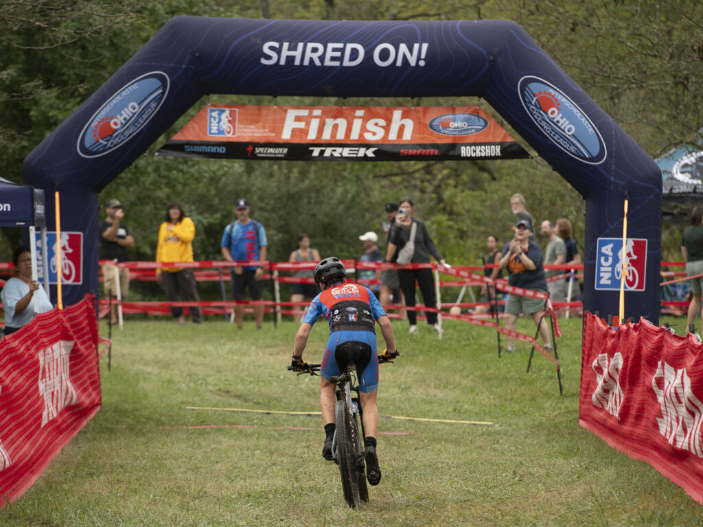 Person riding bike through finish line